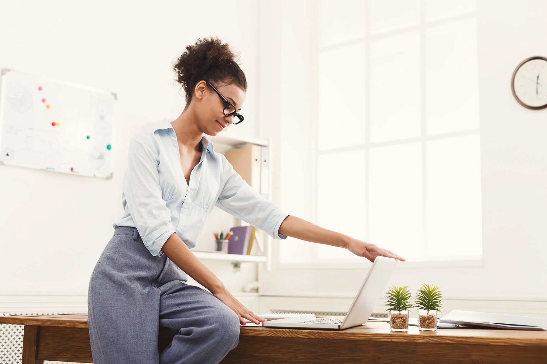 business-woman-opening-laptop-at-office-PU4ZAGW_rtl-min